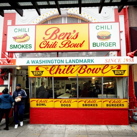 the outside of ben's chili bowl in washington dc with a couple people standing in front