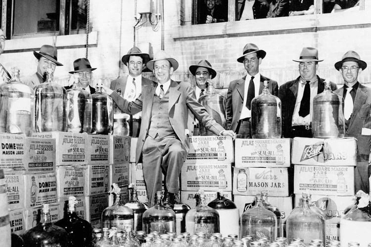 Moonshine bust, group poses with confiscated illegal liquor outside Johnson County Courthouse, 1951. Mason jars were used -- but our writer thinks the modern-day use of Mason jars is overrated.