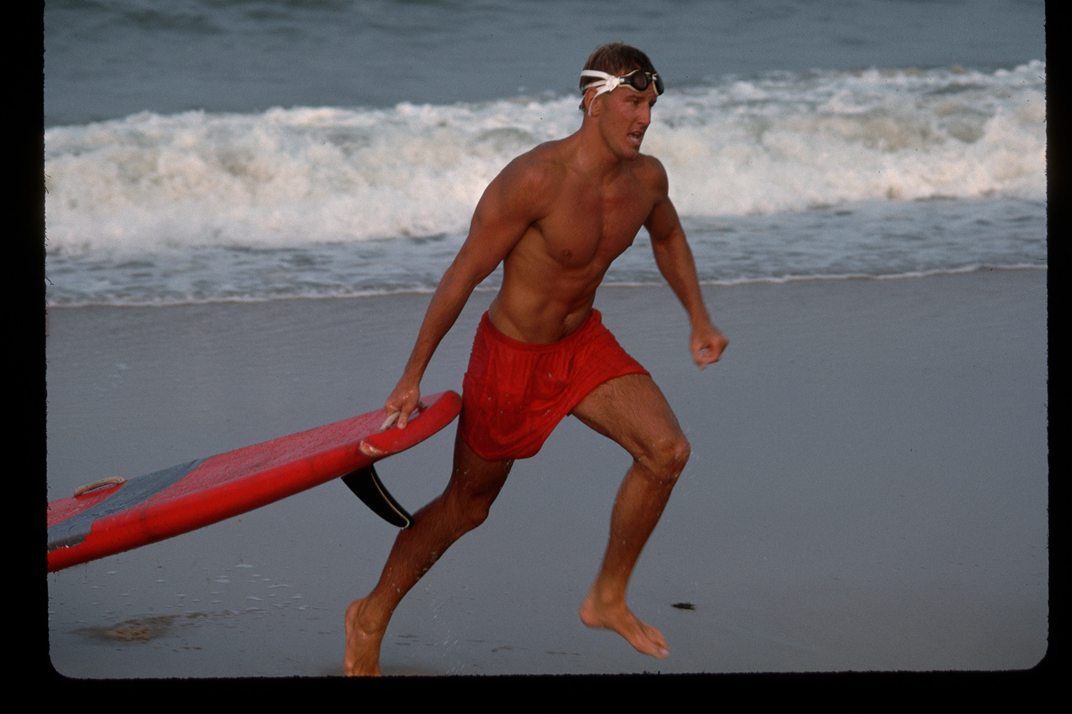 A lifeguard running across the beach. Here's how to get in shape like a lifeguard.
