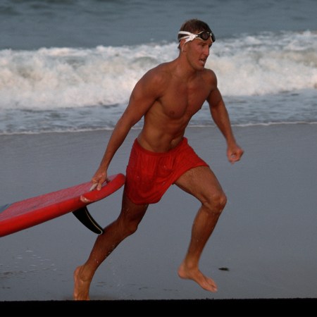 A lifeguard running across the beach. Here's how to get in shape like a lifeguard.