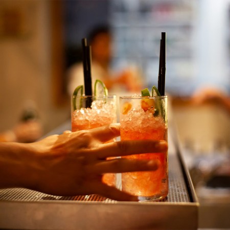 A bartender grabbing a bunch of cocktails during happy hour. We list the best happy hours around San Francisco.