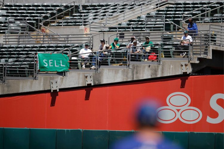 Oakland Athletics fans with signs begging ownership to sell the team.