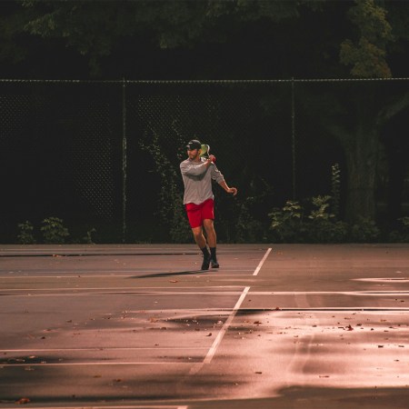 A man running around on a tennis court.