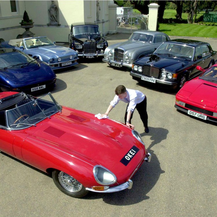 Christie's Car Specialist Rupert Banner polishes the bonnet of rock star Elton John's 1965 Jaguar E Type 4.2 Roadster at Stoke Park Club in Buckinghamshire