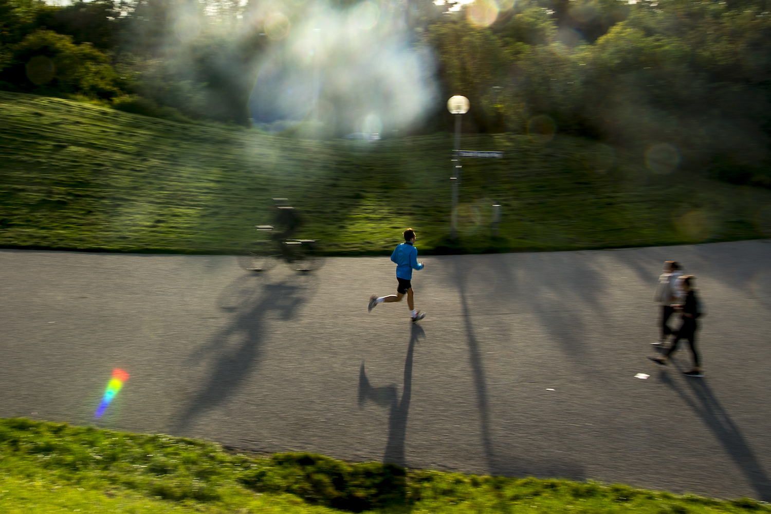 A man running through a park as the sun sets.