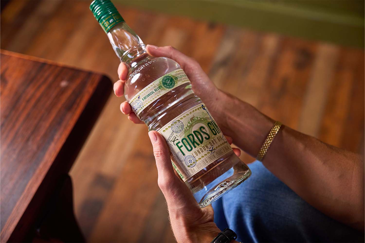 A bottle of Fords Gin being held (off-screen)