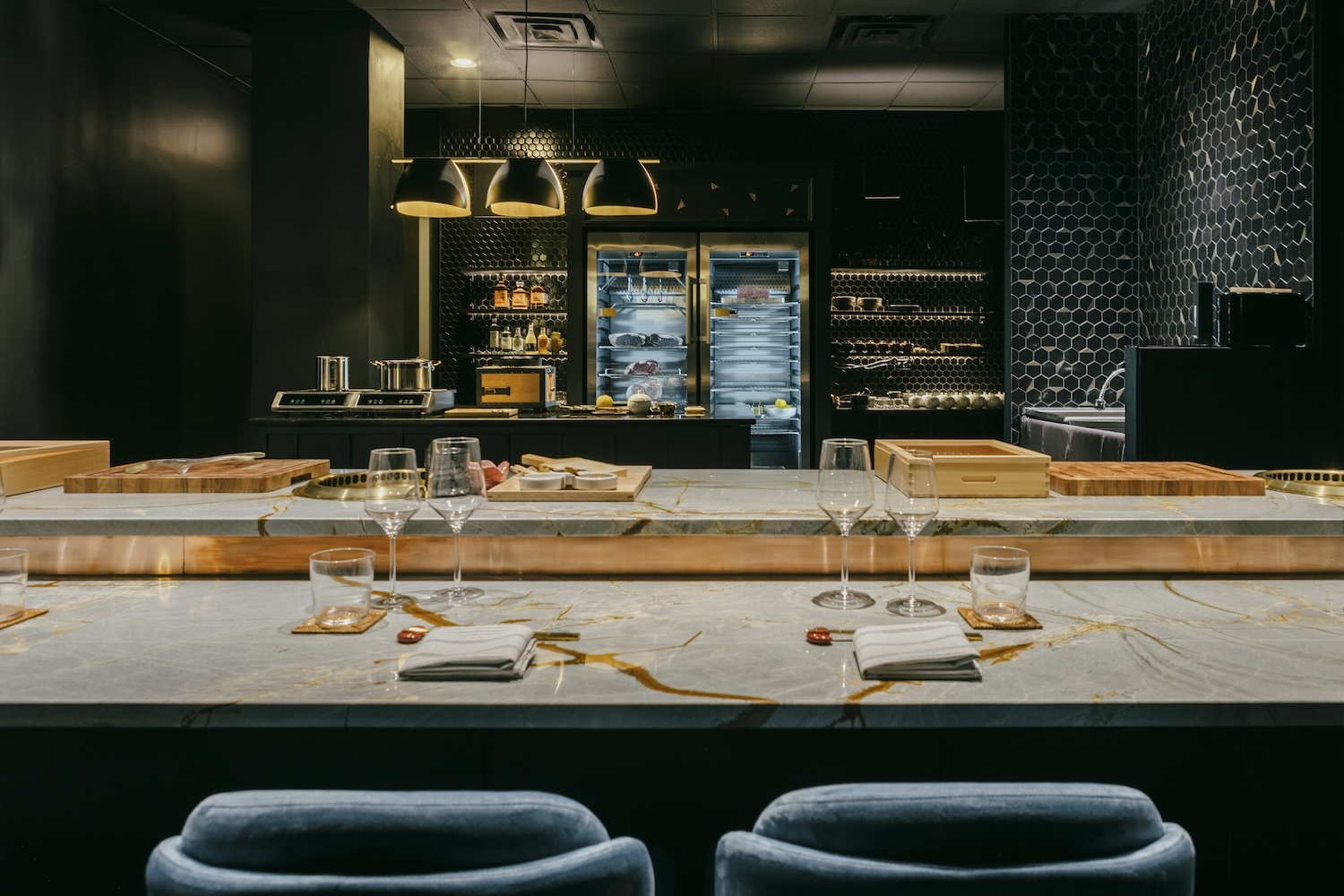 Marble bar with tall blue bar stools at omakase restaurant Bonyeon in Chicago