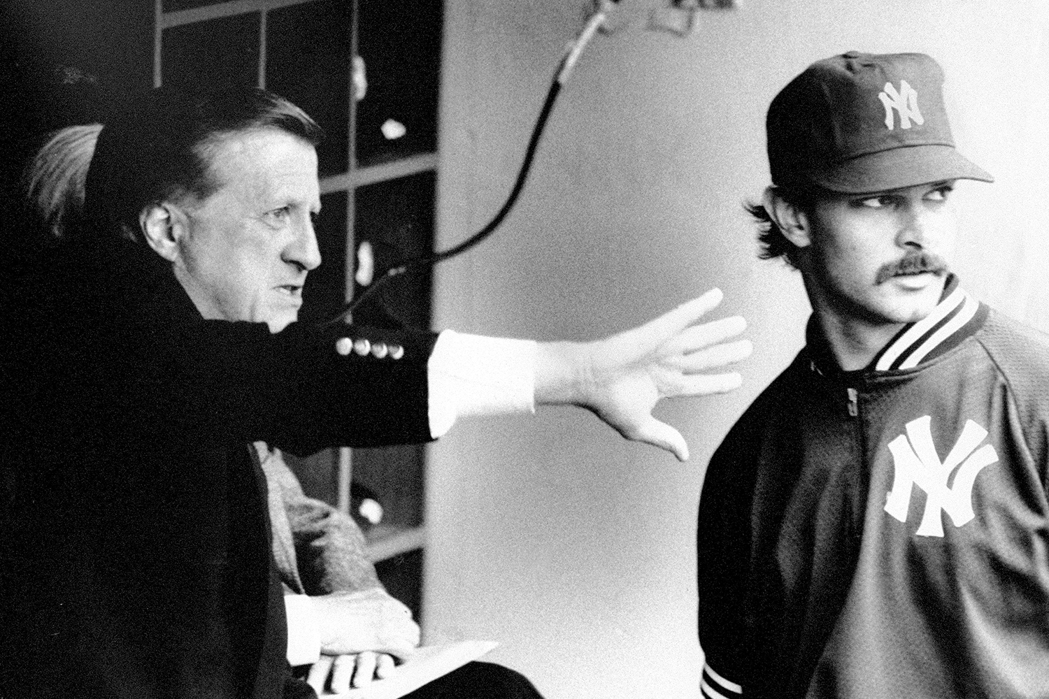 George Steinbrenner gestures to Don Mattingly in the Yankee dugout.