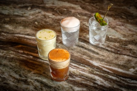 4 cocktail shots sitting on a wooden table