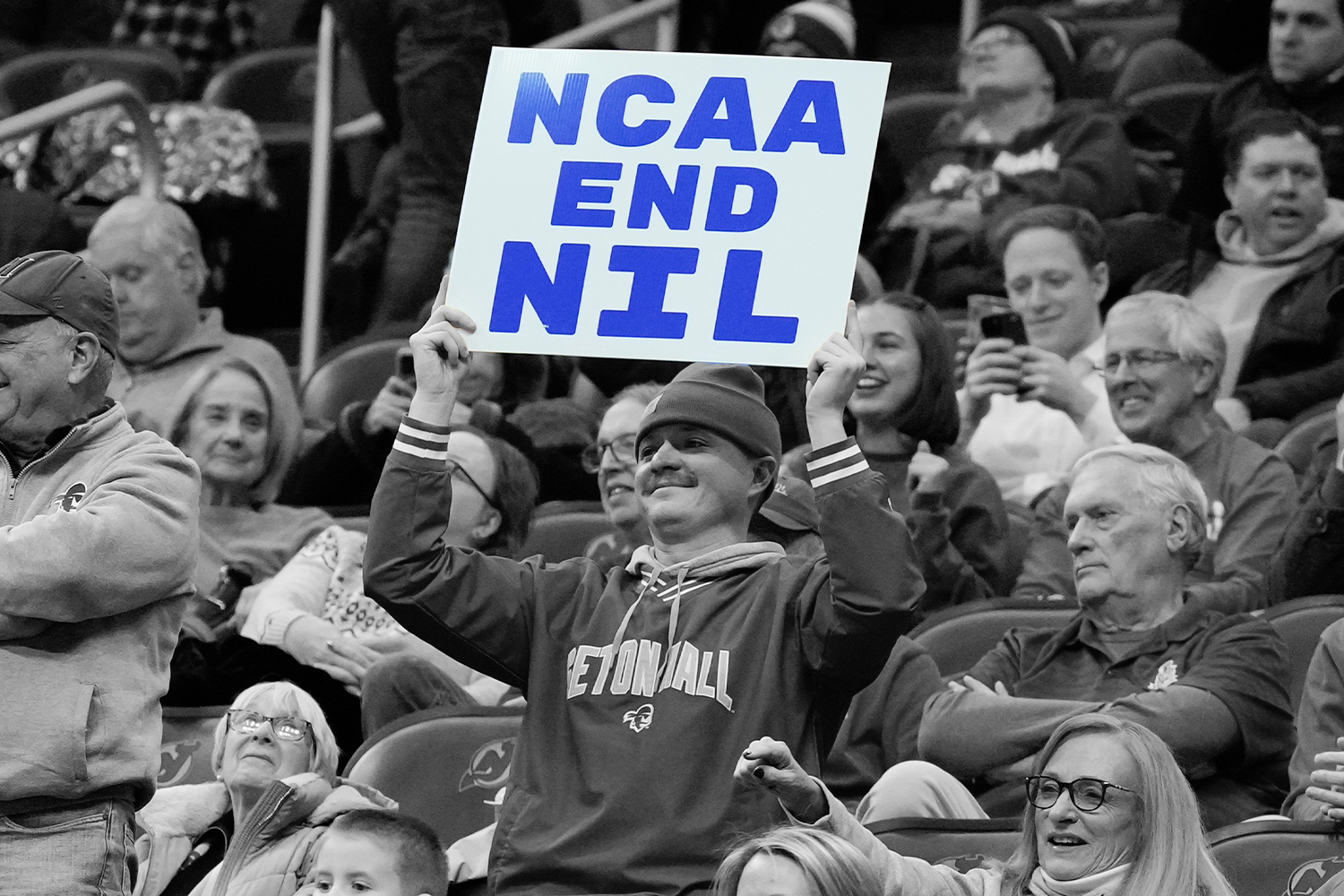 A fan holds a sign reading “NCAA End NIL” at a college basketball game between the Seton Hall Pirates and the DePaul Blue Demons at Prudential Center on January 8, 2025 in Newark, NJ