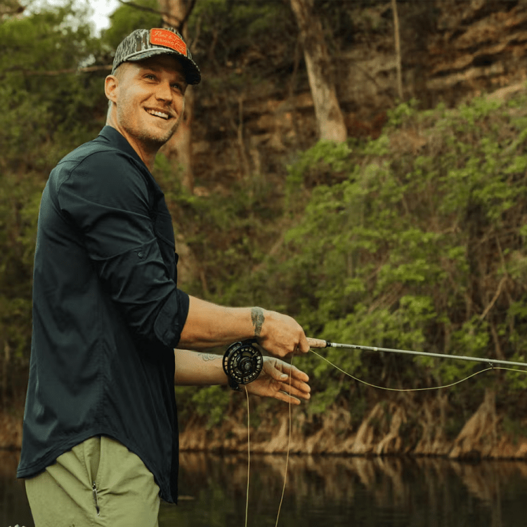 A man fishing wearing items purchased from Huckberry