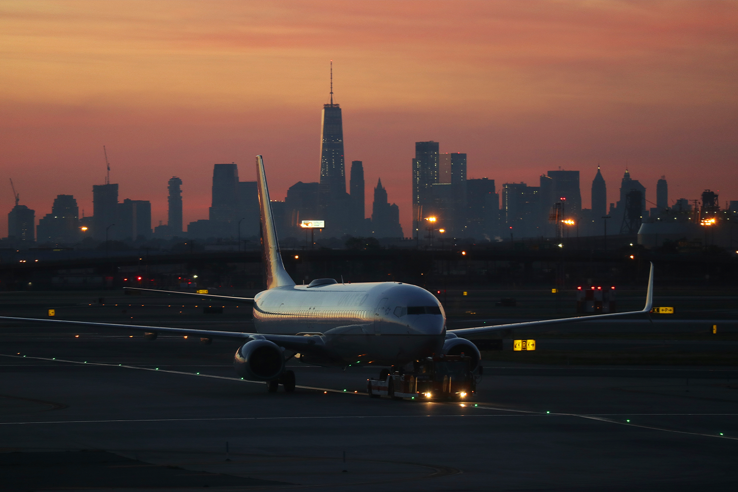 An aircraft taxing at Newark International Airport at dawn