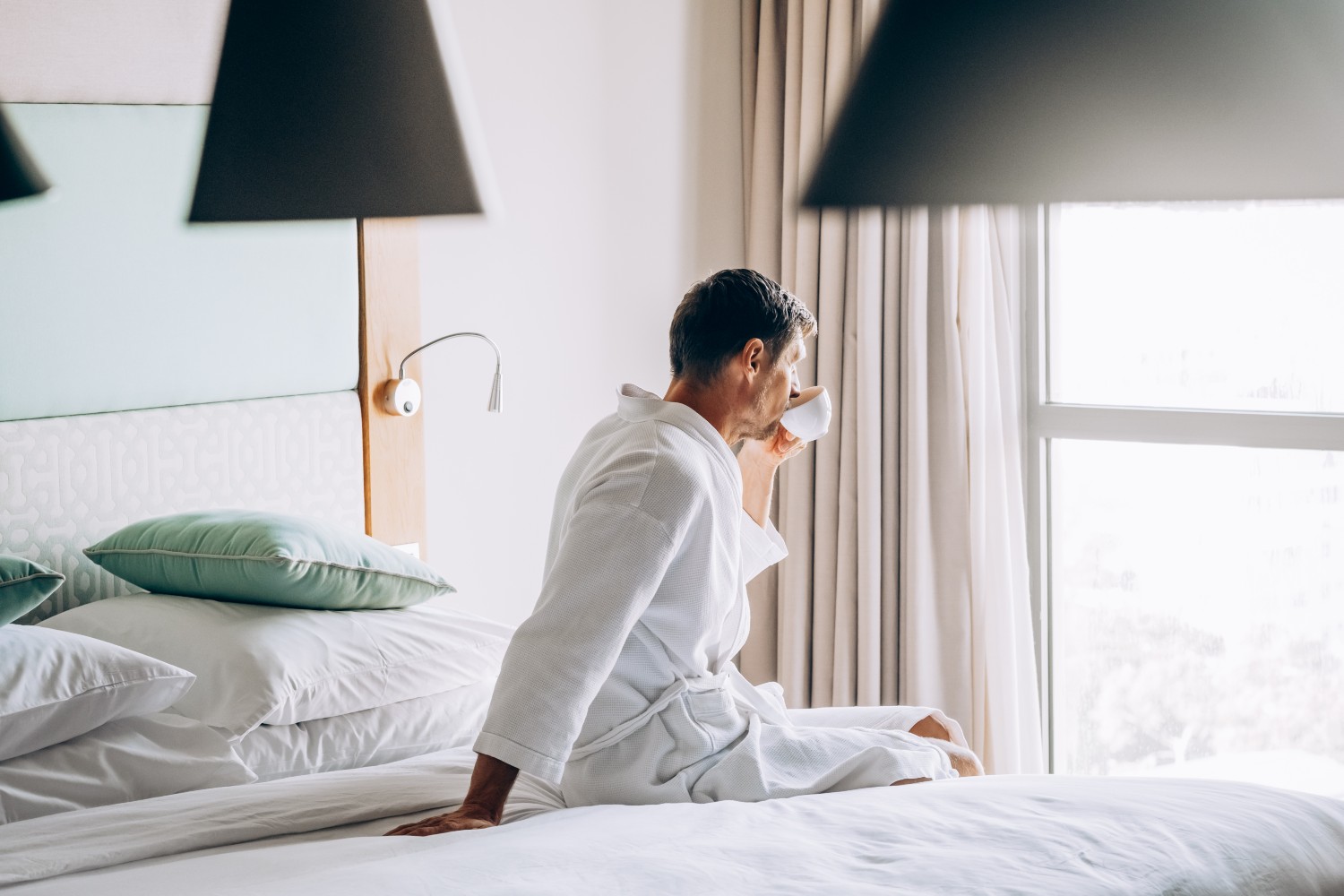 Man drinking coffee in bed