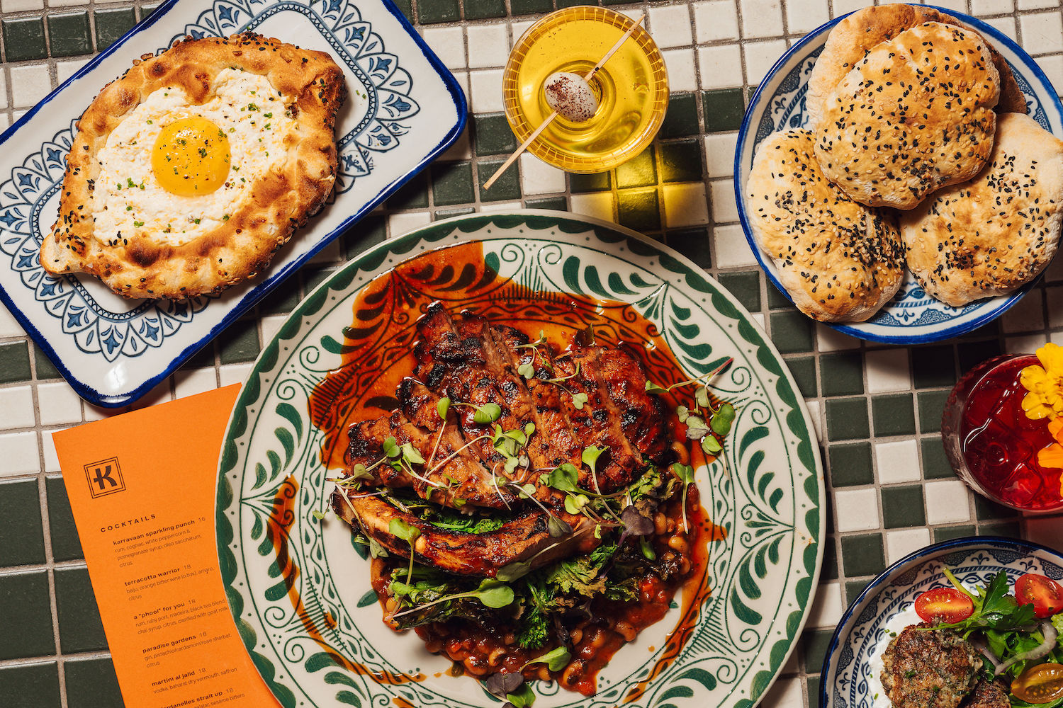 grilled meat, georgian bread and pita on a white and green tiled table