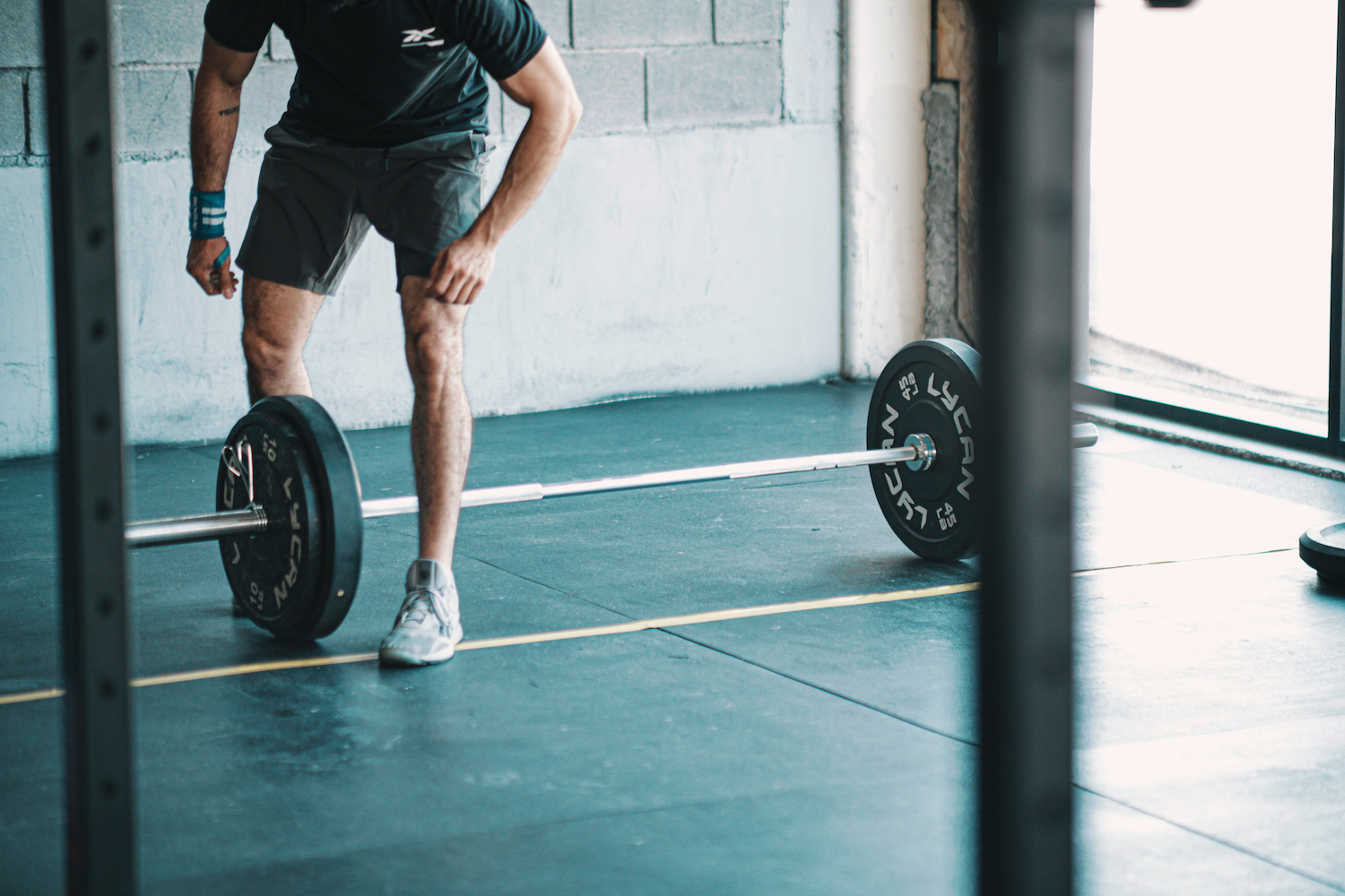 A man leaning over a barbell.
