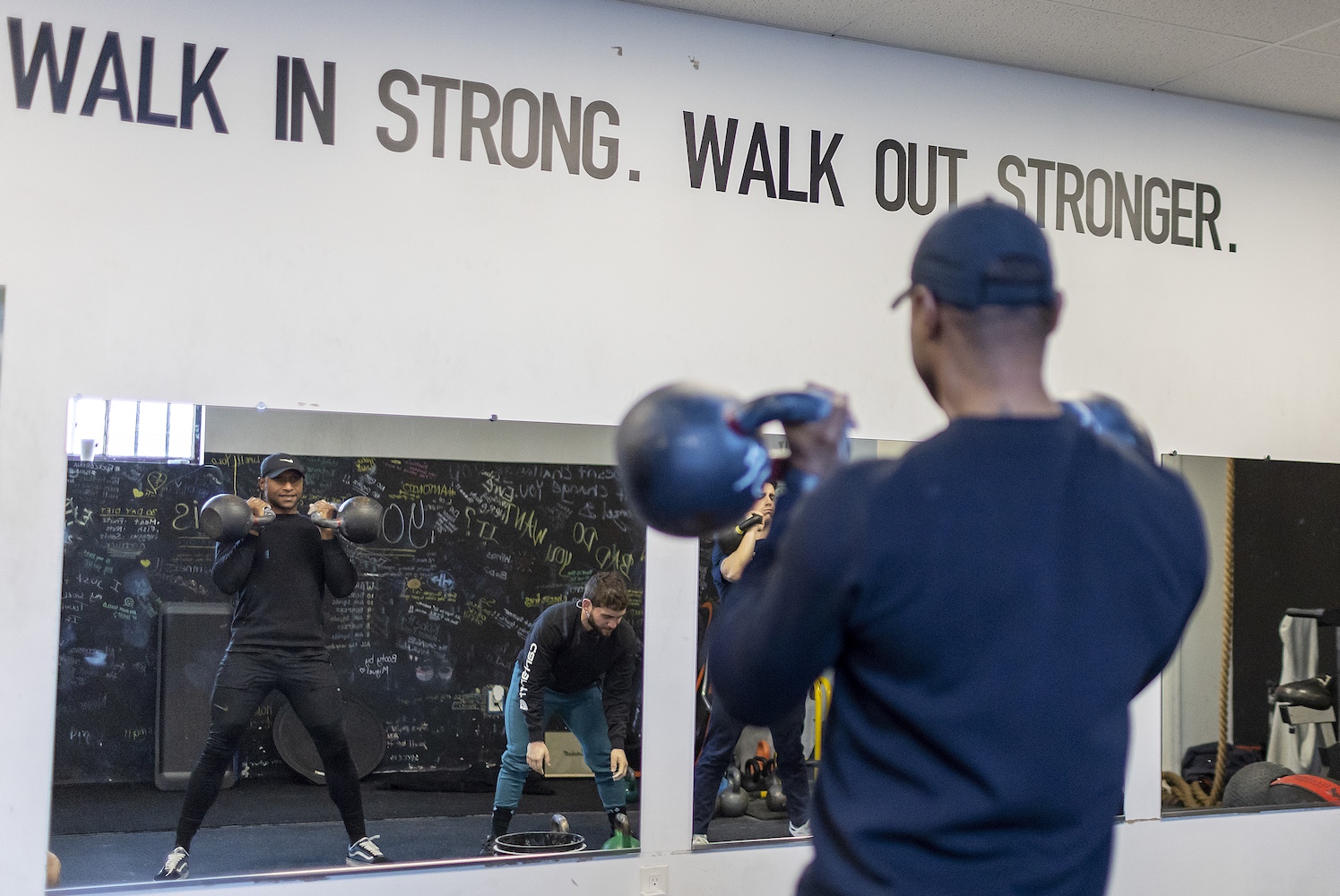 A man lifting kettlebells during a freestyle gym workout session.