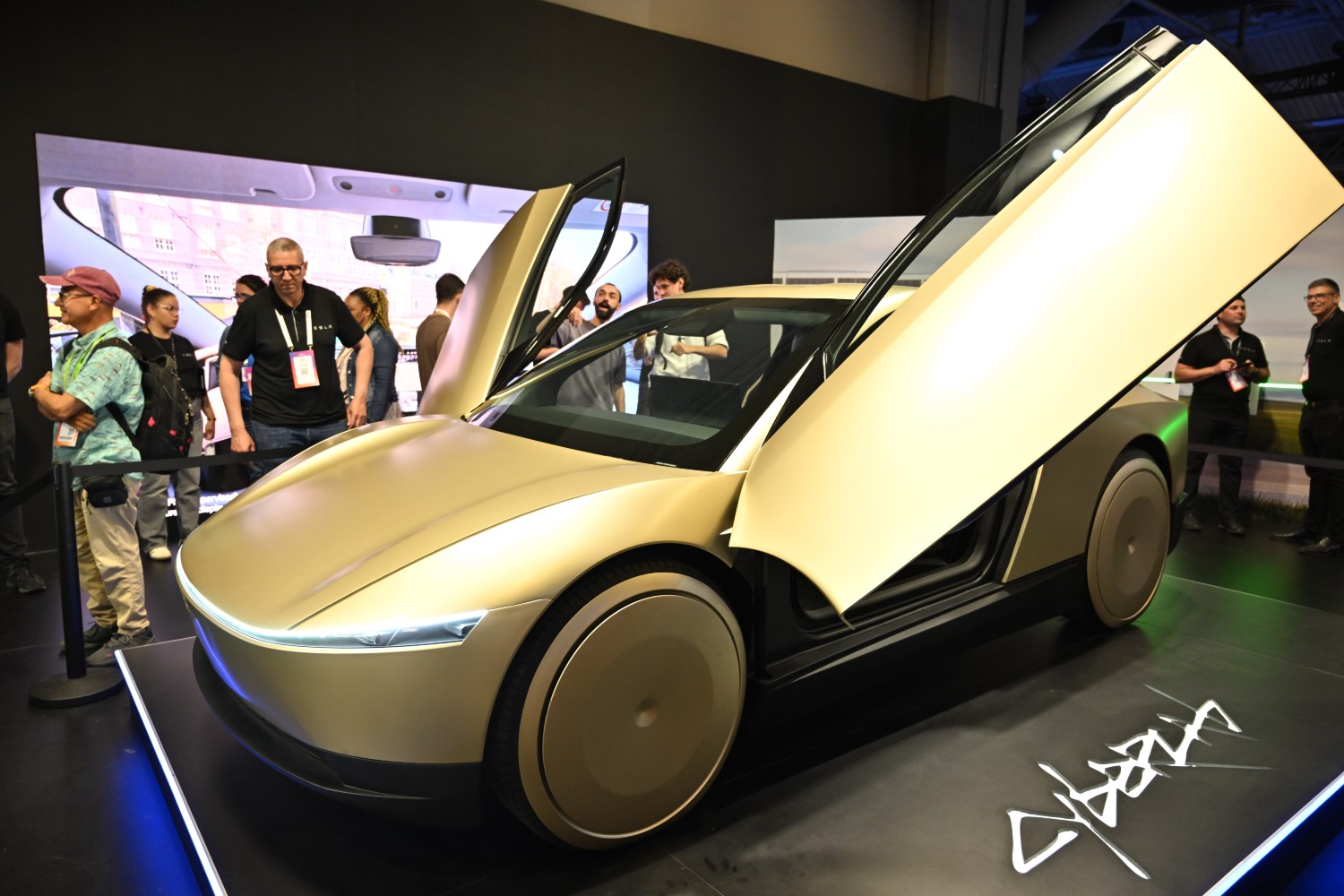 A golden Tesla robotaxi with the doors open