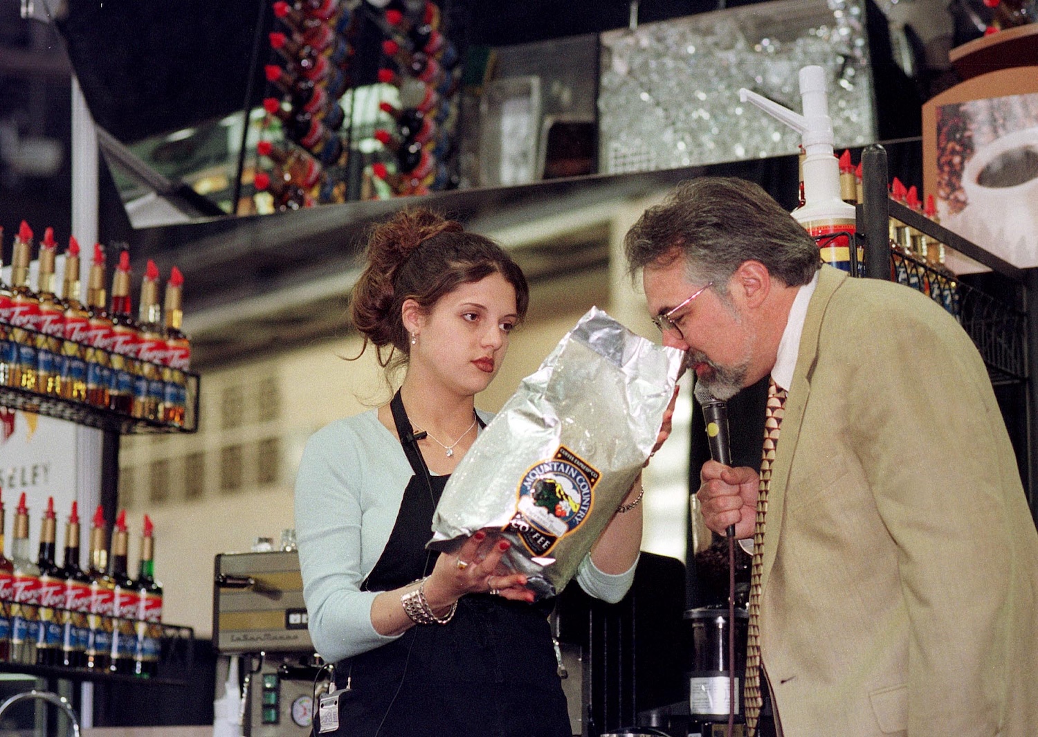 Christina Gibbs, left, of Saginaw, Michigan, holds up the brand of coffee she was using to make espresso, as Paul Songer, one of the judges, sniffs the beans, during the Torani 5th Annual Barista Cup, Saturday, May 1, 1999