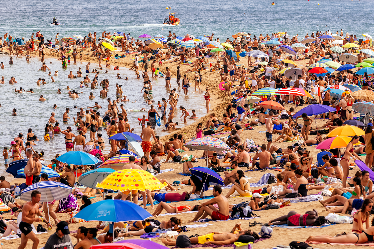 Tourists crowd a beach in Barcelona