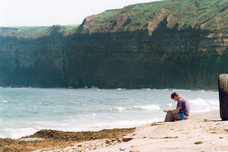 A man taking in the air at Saltburn Beach.