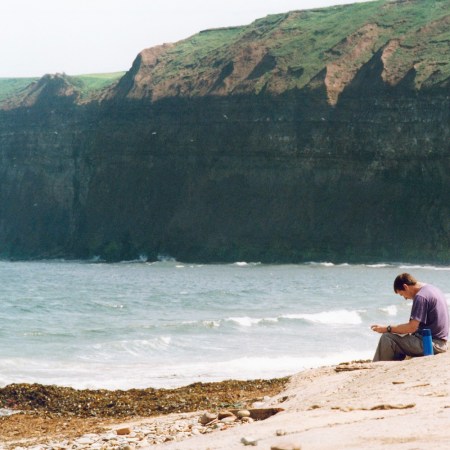 A man taking in the air at Saltburn Beach.