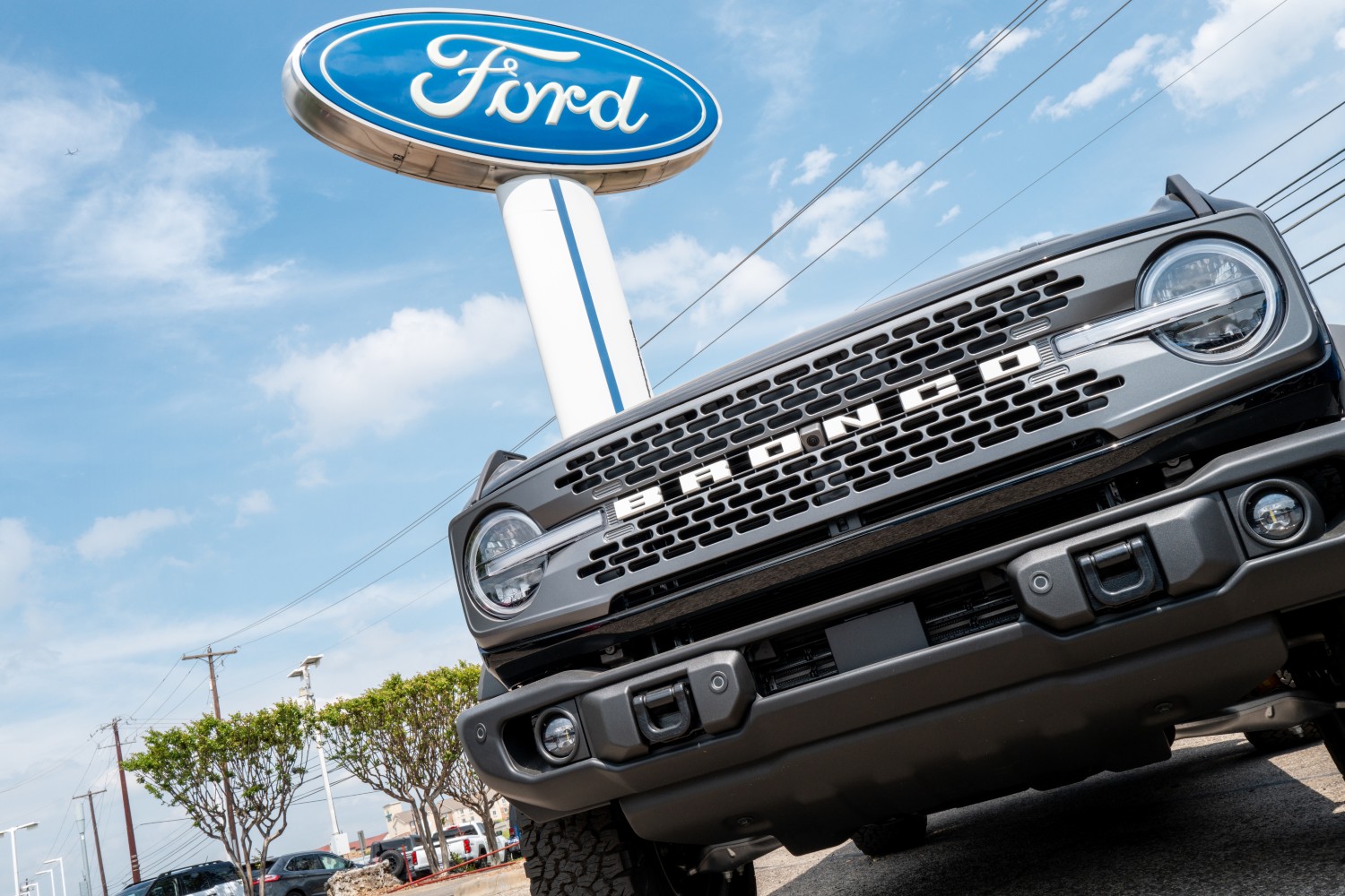 Ford Bronco parked under a Ford sign