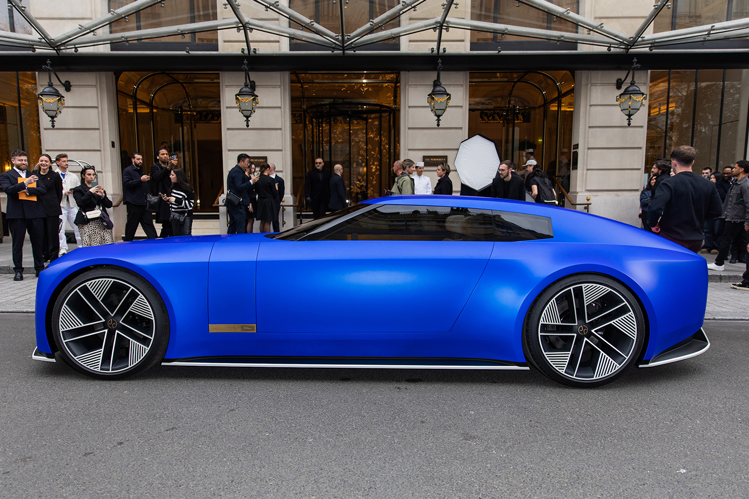 The Jaguar Type 00 concept car in blue sitting next to a curb during Paris Fashion Week