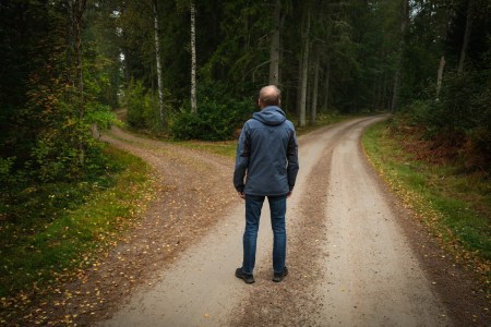 Man standing at a crossroads in the woods