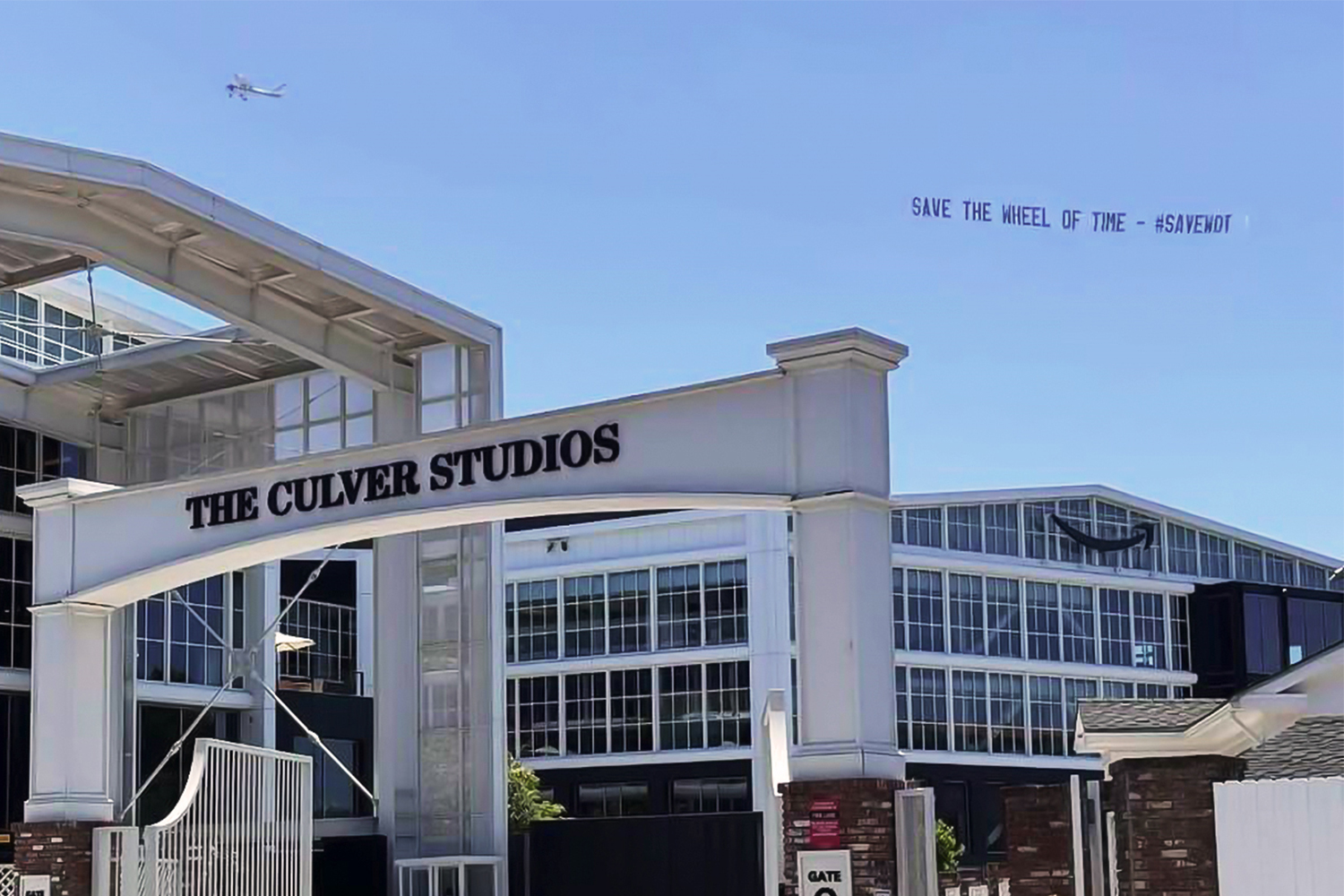 An airplane with a sky banner that reads "Save The Wheel of Time - #SAVEWOT" flying over Culver Studios, which includes Amazon MGM Studios
