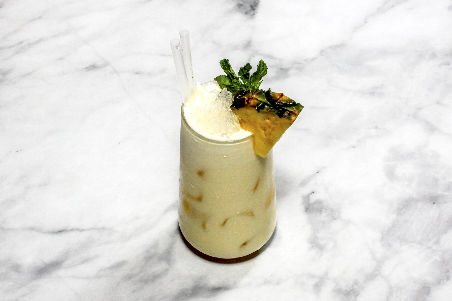 A cocktail ''Pina colada'' is sitting on a bright background