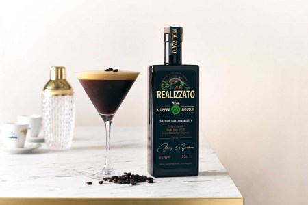 A bottle of Realizzato and an espresso martini on a table