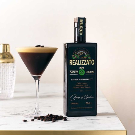 A bottle of Realizzato and an espresso martini on a table