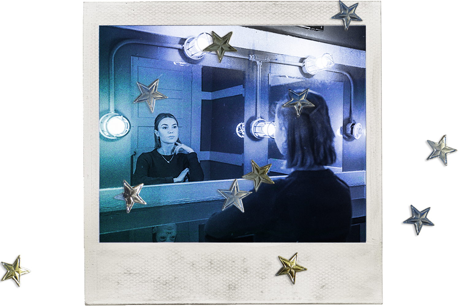 Stand-up comic Kelsey Cook looks into a mirror with lights around the sides