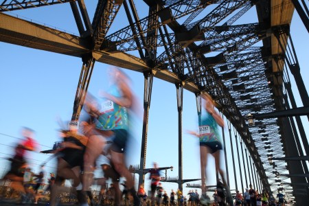 A photograph of blurry runners crossing a bridge.
