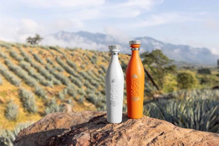 Escasa Tequila bottles in front of agave fields