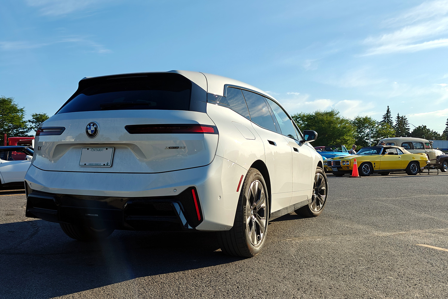 A BMW iX xDrive60 electric SUV at a car show in a parking lot