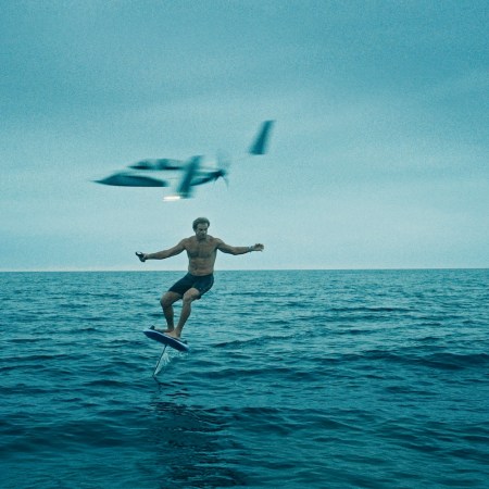A still from Laird Hamilton's documentary "Dawn Ready" — he's on a hydrofoil with a plane behind him.