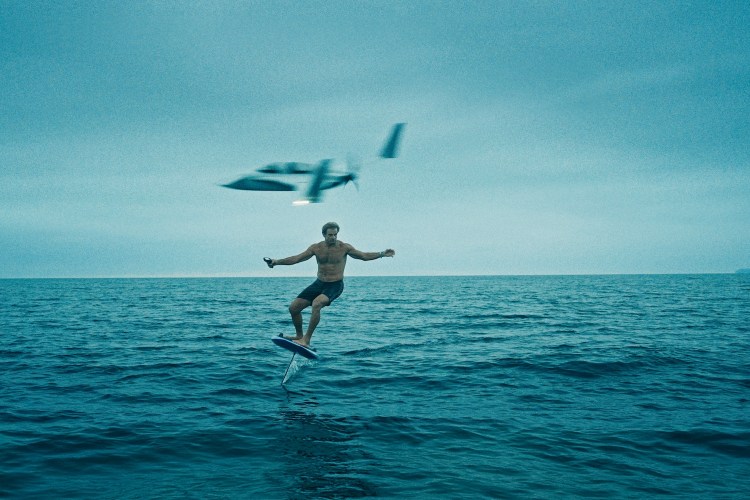 A still from Laird Hamilton's documentary "Dawn Ready" — he's on a hydrofoil with a plane behind him.