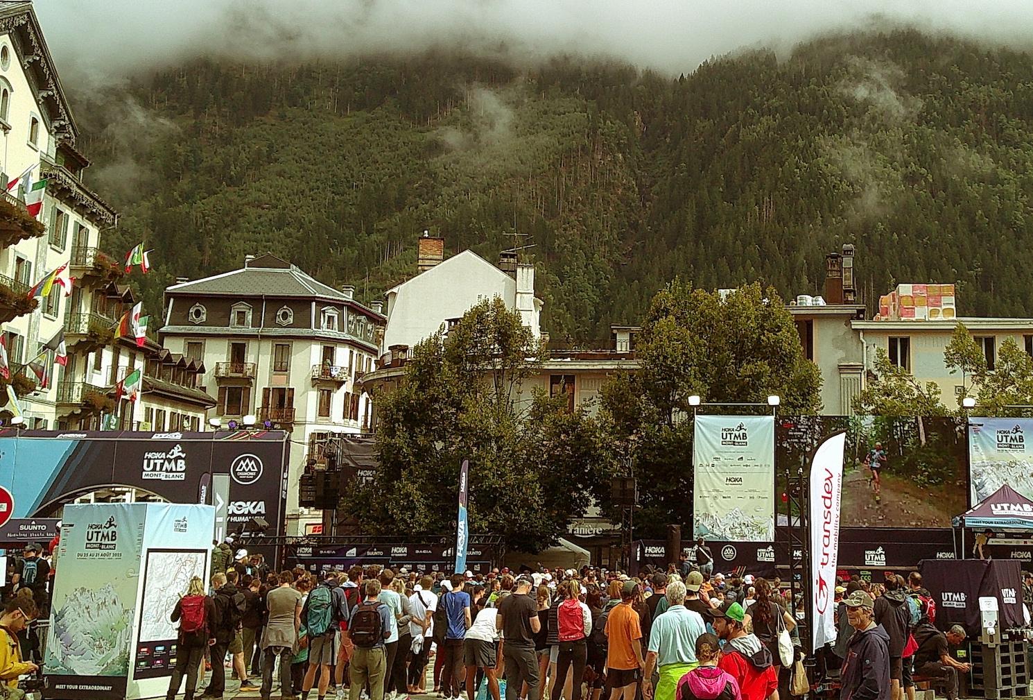 A view of people watching UTMB on a large outdoor TV.