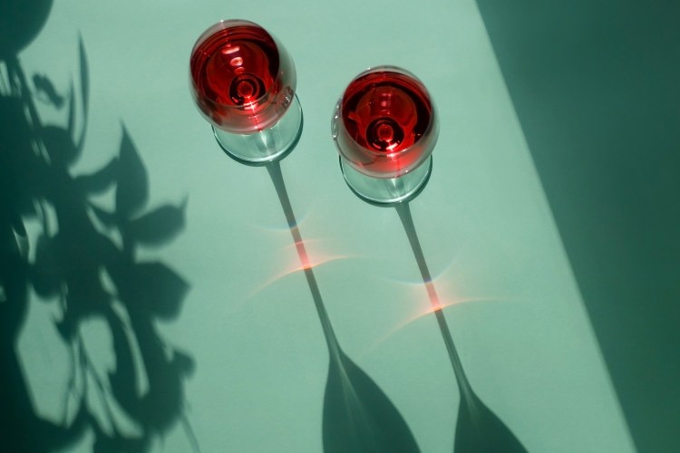 Two glasses of wine casting long shadows