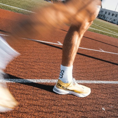 A pair of legs running quickly around a track.