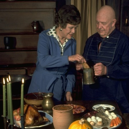 Julia Child and James Beard standing behind a table arrayed w. autumnal foods while appearing on TV show Revolutionary Recipes