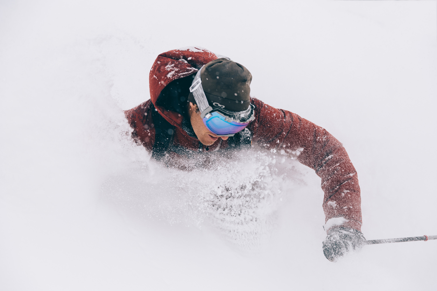 A man skis through a spray of snow.