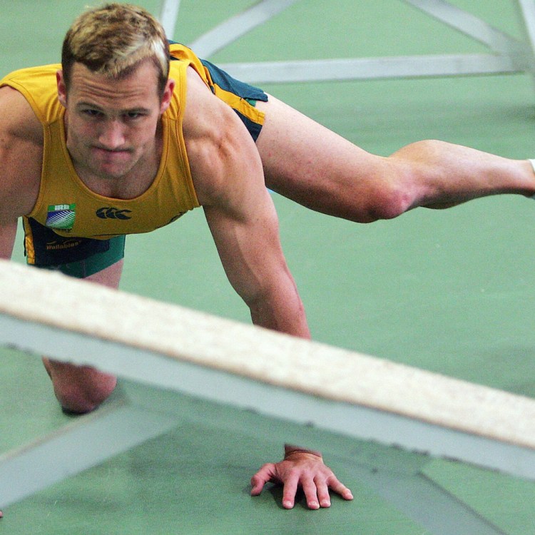 A rugby captain practicing fire hydrants for hip mobility.