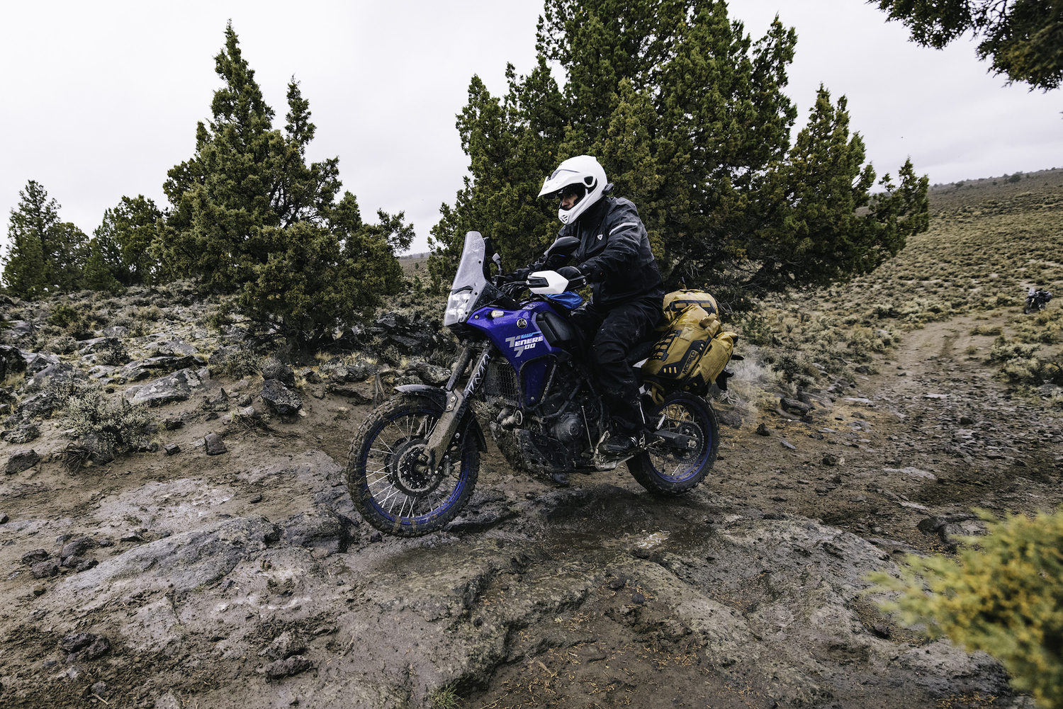 A man on a motorcycle with slick terrain beneath him.