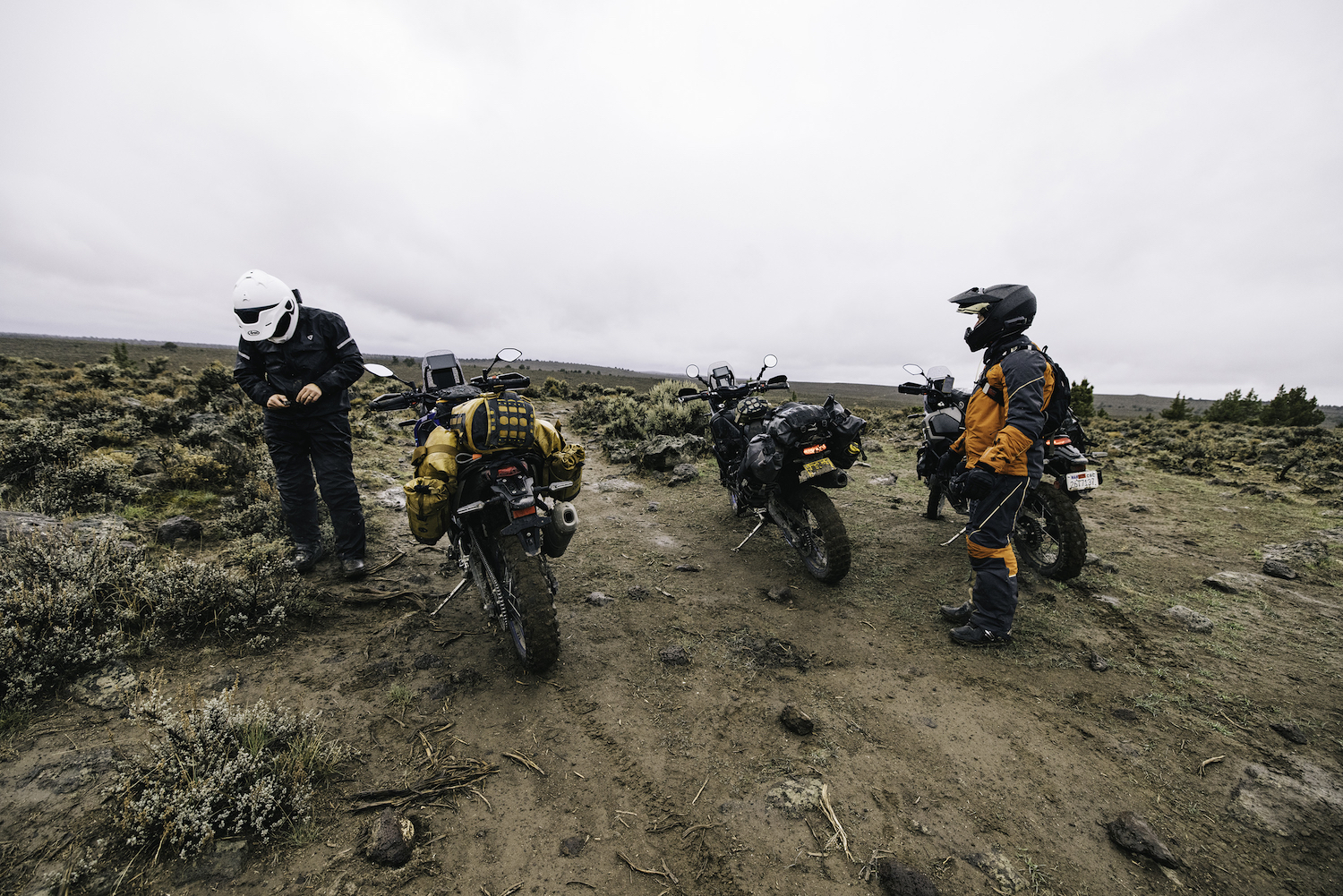 Two men stand next to motorcycles in remote Oregon.