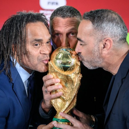 Soccer players kissing the World Cup trophy