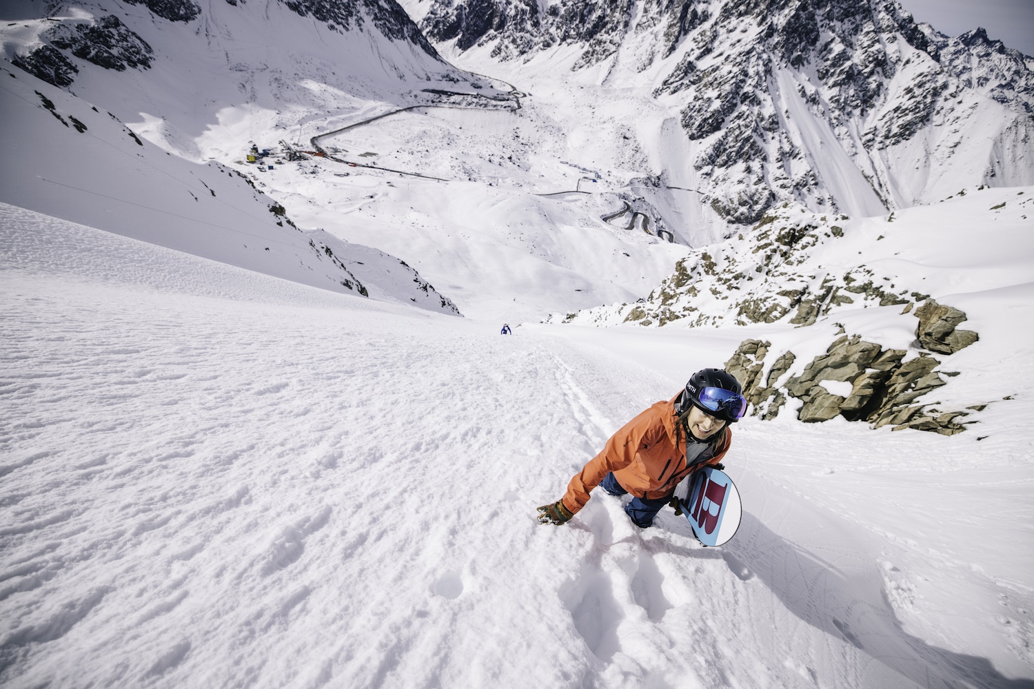 A woman bootpacking up the side of a ski mountain.