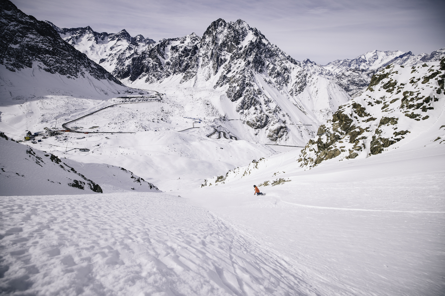 A lone skier makes their way down the mountain.