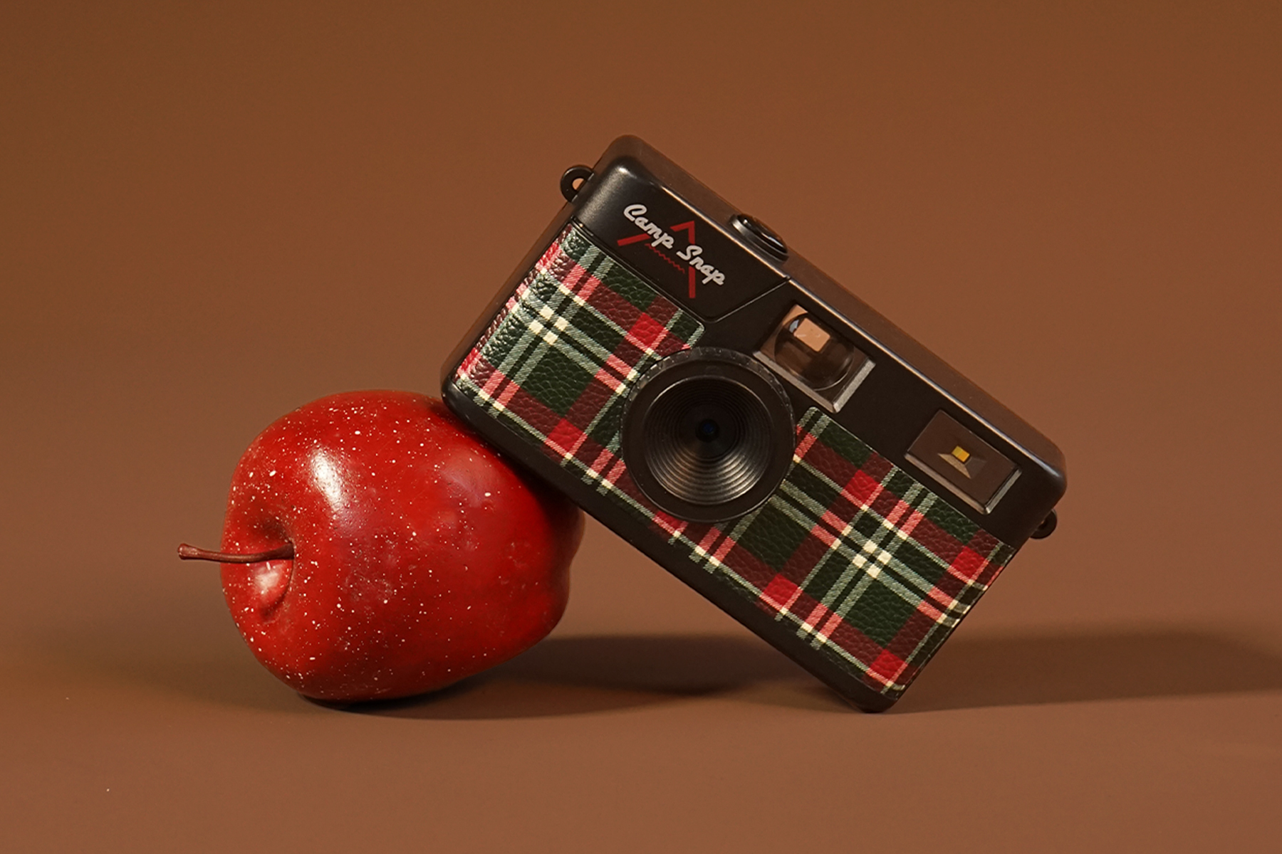 A Camp Snap camera leaning on an apple. The tech gift is one of 40 gifts we picked under $50.
